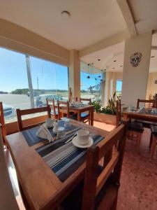een eetkamer met een tafel en stoelen en uitzicht op de oceaan bij Hotel Gran Bacu in Mar de Ajó