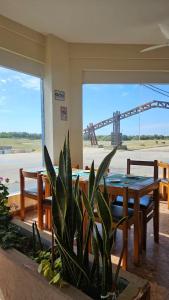 een eetkamer met een tafel en banken en uitzicht op een kraan bij Hotel Gran Bacu in Mar de Ajó