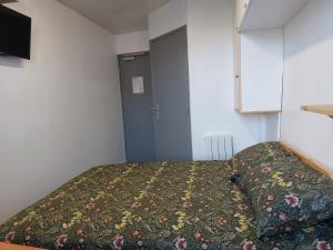 een kleine slaapkamer met een bed en een kast bij Paisible in Les Pieux