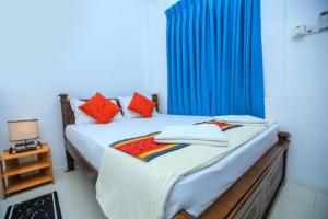 Un dormitorio con dos camas y una cortina azul. en SaRu Holiday Apartments - 2BR 6 Guests, en Kandy