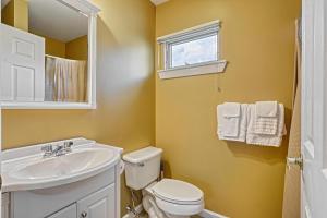 ein Badezimmer mit weißer Toilette und Waschbecken in der Unterkunft Suites On Chocolate - The Theater in Hershey