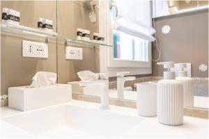 a bathroom with white furniture and a mirror at Tiffany Silver in Burano +60 photos