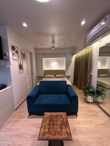 a living room with a blue couch and a bed at The Tira luxe in Pune