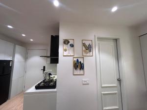 a white kitchen with a stove and pictures on the wall at The Tira luxe in Pune +13 photos