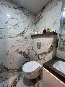 a bathroom with a white toilet and a sink at The Tira luxe in Pune