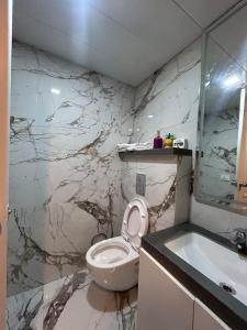 a bathroom with a toilet and a sink and a tub at The Tira luxe in Pune