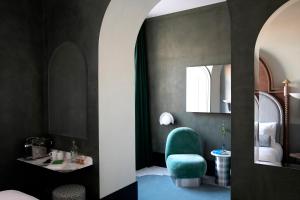 a room with a green chair and a mirror at Il Palazzo Experimental in Venice +33 photos