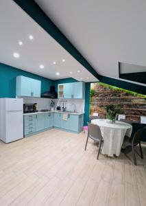 een keuken en eetkamer met blauwe kasten en een tafel bij Storico17 in Catania