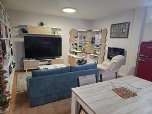 a living room with a blue couch and a tv at Villa Maritxu in Cangas de Morrazo