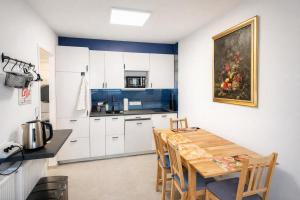 a kitchen with white cabinets and a wooden table at Eifeltraum in Daun