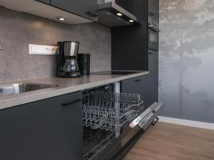 a dishwasher in a kitchen next to a sink at Kubus Nr. 228 | 4 Pers. in Zeewolde