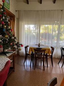een eetkamer met een kerstboom en een tafel en stoelen bij Are-Kepay in Villa Carlos Paz +8 foto's