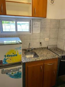 een kleine keuken met een spoelbak en een fornuis bij Are-Kepay in Villa Carlos Paz