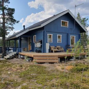 a blue house with a large wooden deck at Yläkolo - A functional cottage in a good location in Saariselka