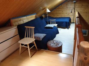 a attic room with two beds and a chair at Yläkolo - A functional cottage in a good location in Saariselka