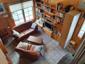 a living room with a couch and a tv at Yläkolo - A functional cottage in a good location in Saariselka