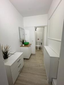 a white bathroom with a toilet and a sink at Udroiu Residence 2 in Craiova