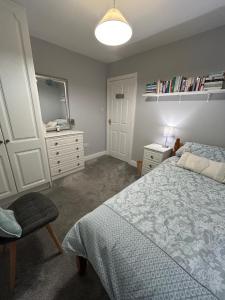 a bedroom with a bed and a dresser and a mirror at Balrath Wood - entire 3 bedroom house with drive and garden sleeps 5 in Kells