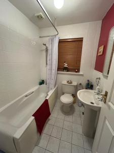 a bathroom with a tub and a toilet and a sink at Balrath Wood - entire 3 bedroom house with drive and garden sleeps 5 in Kells