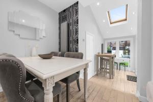 een eetkamer met een witte tafel en stoelen bij 4 Bedroom House With Cinema Room by City SuperHost in Hale