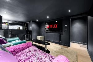 een woonkamer met een paarse bank en een tv bij 4 Bedroom House With Cinema Room by City SuperHost in Hale