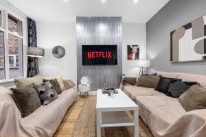 een woonkamer met een bank en een tv bij 4 Bedroom House With Cinema Room by City SuperHost in Hale +24 foto's