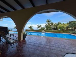 a view of a swimming pool from a house with a chair at Caribbean View in Puerto Limón