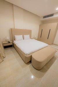 une chambre avec un grand lit blanc dans une pièce dans l'établissement إطلالة الشاطئ, à Dammam