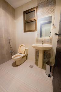 une salle de bains avec toilettes et lavabo dans l'établissement إطلالة الشاطئ, à Dammam