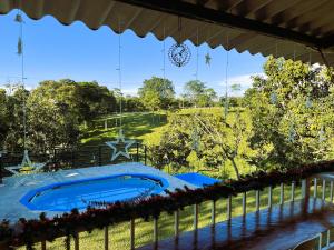 a swimming pool on a fence with a view of a field at Finca cerca Parque del Cafe y Panaca Aves & paisaje in Quimbaya