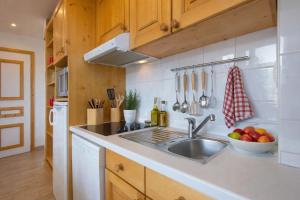 uma cozinha com um lavatório e uma taça de fruta em Résidence & Spa La Grande Cordée - Combloux em Combloux