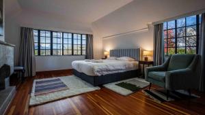 a bedroom with a bed and a chair and windows at Mountain view villa heated pool Nyeri - 2352 in Kuhora Twana +45 photos