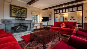 a living room with red furniture and a fireplace at Mountain view villa heated pool Nyeri - 2352 in Kuhora Twana