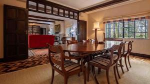 a dining room with a wooden table and chairs at Mountain view villa heated pool Nyeri - 2352 in Kuhora Twana