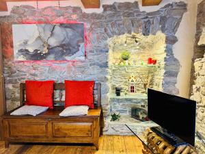 une pièce avec un mur en pierre et un bureau avec un ordinateur dans l'établissement Maison Bovet, à La Salle