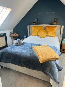 a bedroom with a large bed with yellow pillows at Poppyline Mews in Sheringham