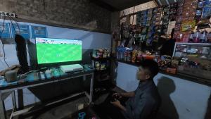 a man sitting in front of a computer in a store at ZOYA HILLS in Pondok Cipaseban +92 photos