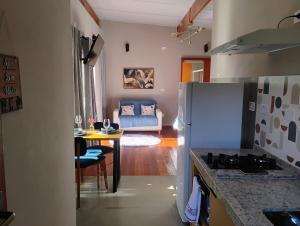een keuken en een woonkamer met een tafel en een koelkast bij Chalé Topázio Gonçalves in Gonçalves