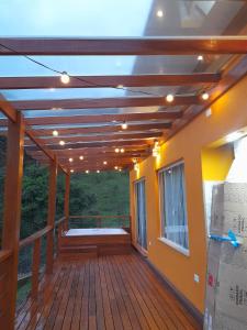 een terras met een houten plafond en verlichting bij Chalé Topázio Gonçalves in Gonçalves
