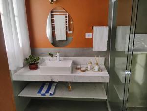 een badkamer met een wastafel en een spiegel bij Chalé Topázio Gonçalves in Gonçalves +11 foto's