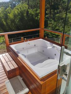 een ligbad bovenop een terras bij Chalé Topázio Gonçalves in Gonçalves