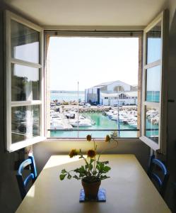 einem Tisch mit einer Pflanze vor einem Fenster in der Unterkunft La goélette - Les Gîtes de la Côte d'Amour in Le Croisic