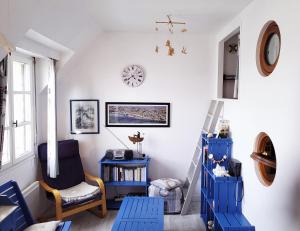 ein Zimmer mit blauen Möbeln und einer Uhr an der Wand in der Unterkunft La goélette - Les Gîtes de la Côte d'Amour in Le Croisic