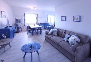 ein Wohnzimmer mit Sofa und Tisch in der Unterkunft La goélette - Les Gîtes de la Côte d'Amour in Le Croisic