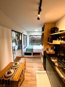 a kitchen with a table and a room with a bed at Villa Manah in Itaúnas