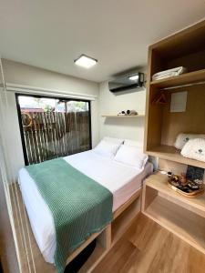 una piccola camera da letto con un letto e una finestra di Villa Manah a Itaúnas