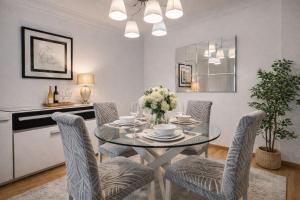 a dining room with a glass table and chairs at Céntrico Apartamento con parking in A Coruña