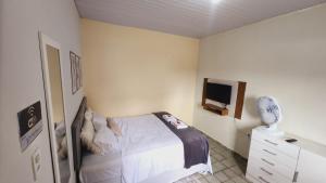 a bedroom with a bed and a dresser and a tv at Sao Luis Praia Studio in São Luís