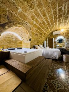 een badkamer met een bad in een kamer met een bed bij Corte Lirice Paradiso in Gioia del Colle