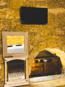 een stenen muur met een tv aan een muur bij Corte Lirice Paradiso in Gioia del Colle